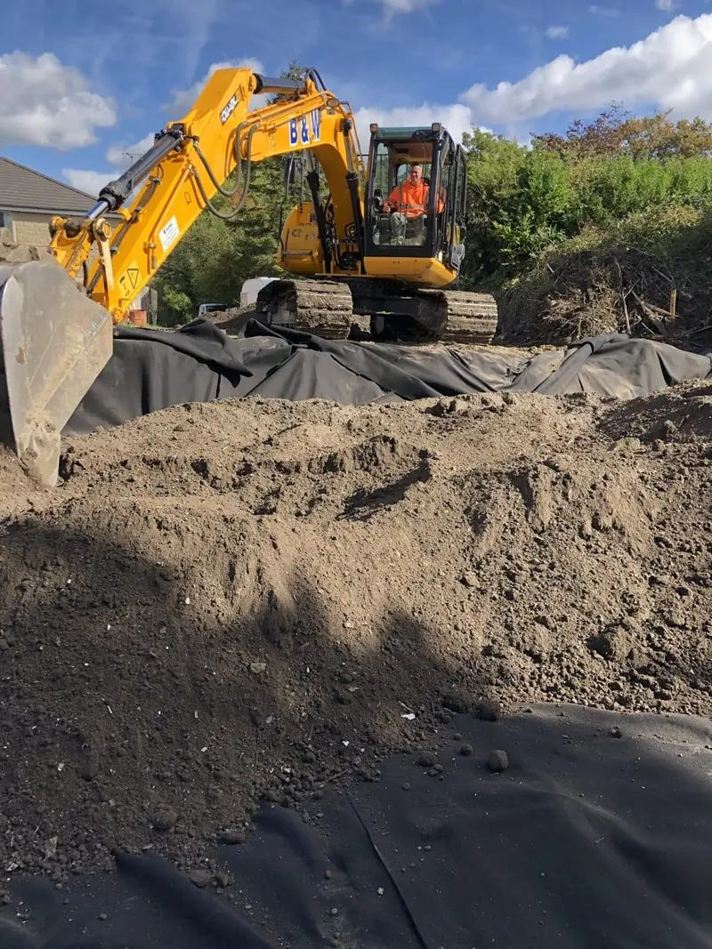 Weedtec excavator working on a site lined with root barrier membrane